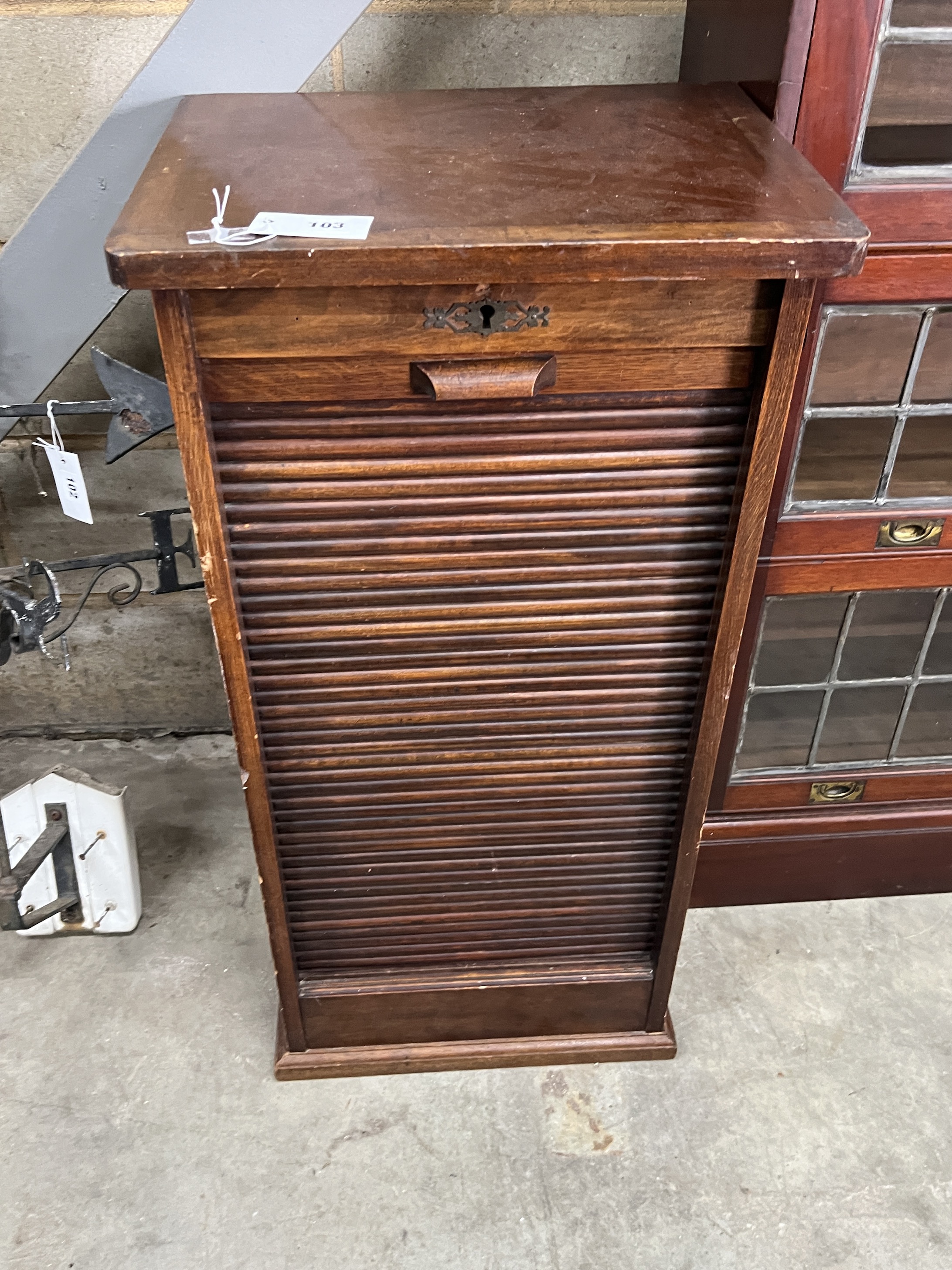 A 1920's oak cabinet with tambour front, width 45cm, depth 36cm, height 92cm